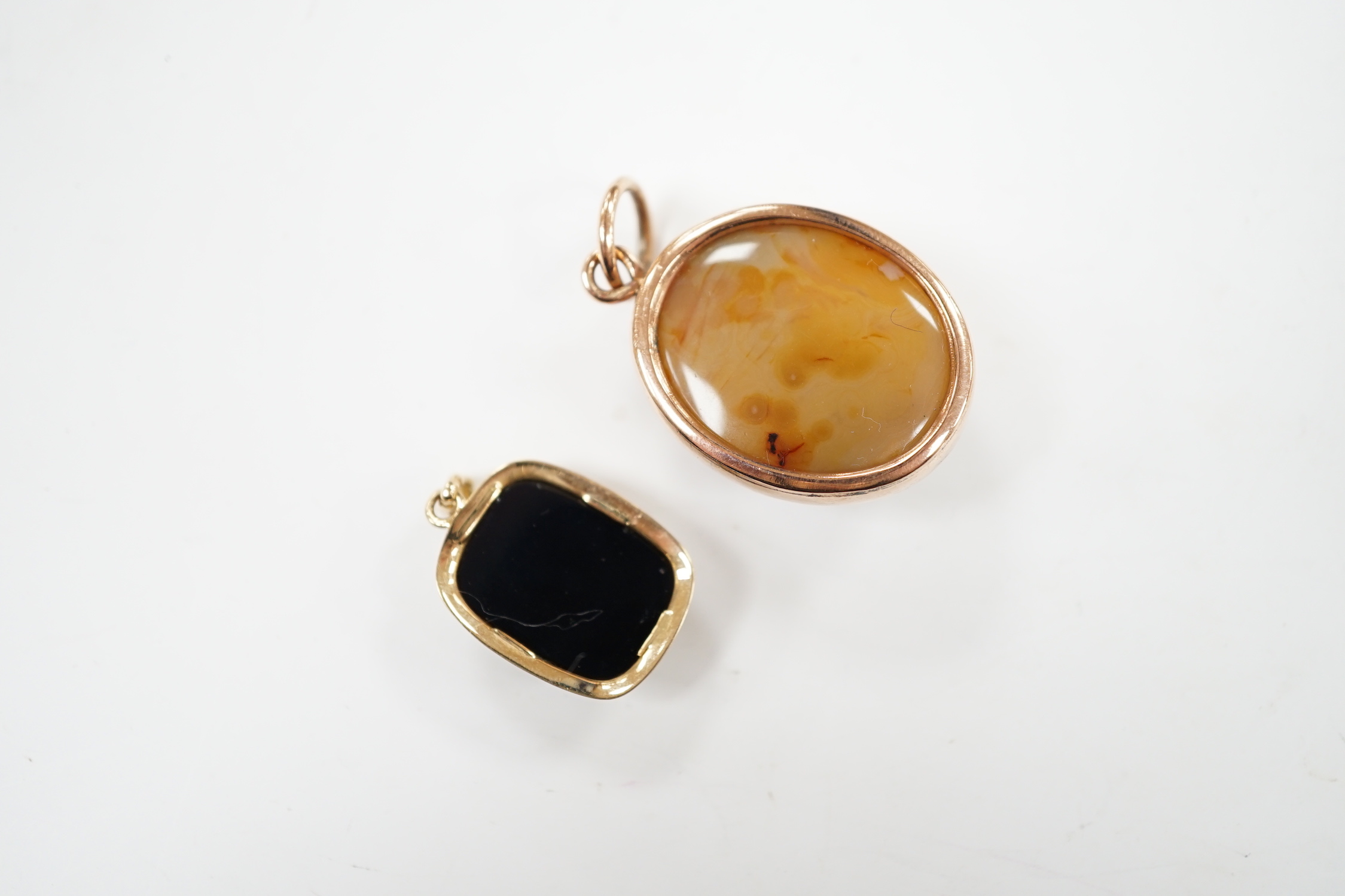A yellow metal mounted oval banded agate pendant, 26mm and a smaller yellow metal mounted sardonyx cameo pendant.